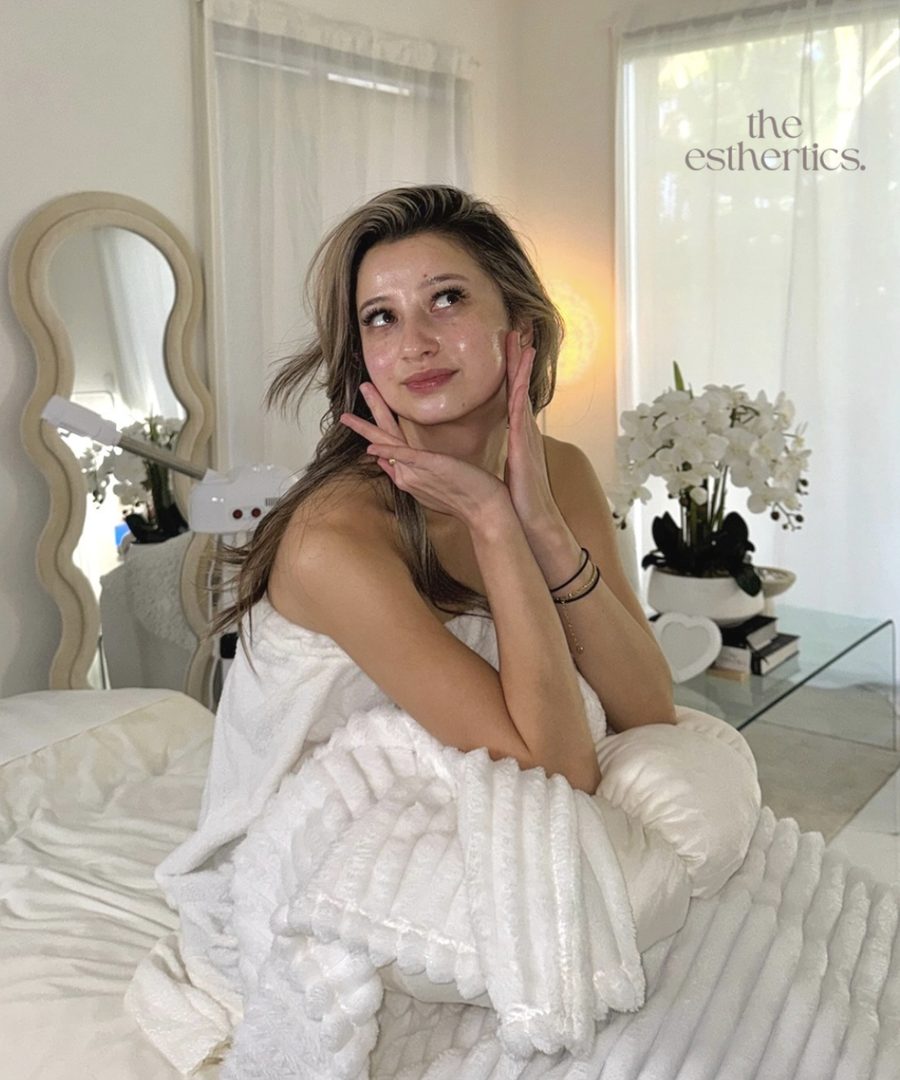 A client with glowing skin wrapped in a white towel on a treatment bed in the clinic