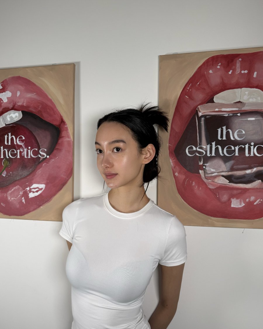 A client of the esthertics. in front of the clinic's lip artwork